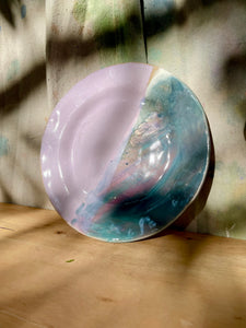 Round ceramic plate with a marbled design on a wooden surface